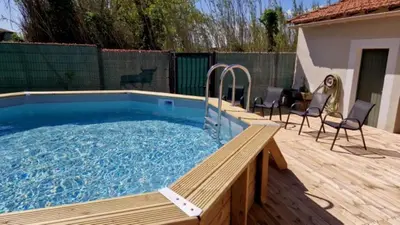 a large swimming pool with a wooden deck and chairs at Camargu'Alpilles in Mollégès