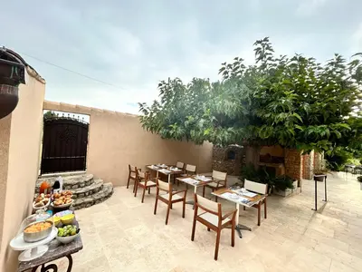 a patio with a table and chairs and a table with food at Les Cachots in Roussillon
