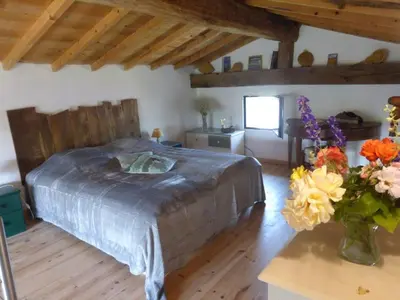 a bedroom with a bed and a vase of flowers at Le grangeon des Hermas in Sault-de-Vaucluse