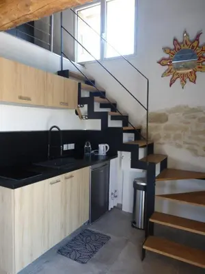 a kitchen with a spiral staircase in a house at Le grangeon des Hermas in Sault-de-Vaucluse