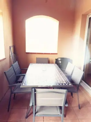 a table and chairs in a room with a large screen at Petit cocon en Provence in Mallemort