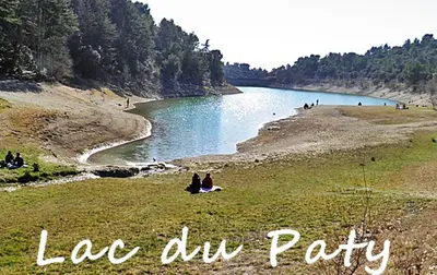 a group of people sitting on the grass near a lake at Villa face au Mont Ventoux avec bassin in Modène