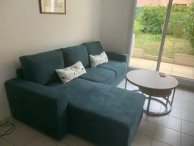 a blue couch in a living room with a table at Appartement, 1 chambre, jardin privatif in Venelles