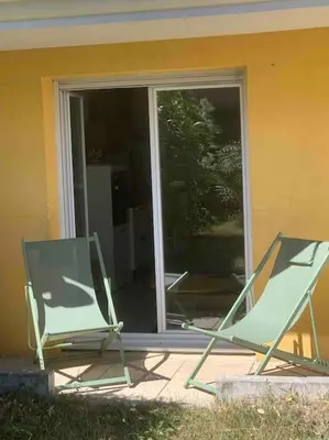 two chairs sitting on a porch in front of a window at Appartement, 1 chambre, jardin privatif in Venelles