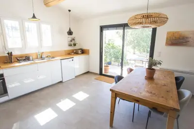 a kitchen and dining room with a wooden table at Maison avec jardin in Saumane-de-Vaucluse