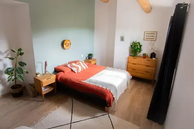 a bedroom with a bed with a red blanket at Maison avec jardin in Saumane-de-Vaucluse