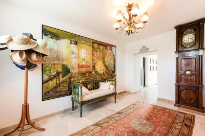 a living room with a couch and a large painting on the wall at Beautiful Provencal Mas with swimming pool in Le Thor