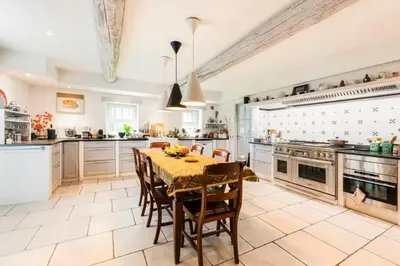 a large kitchen with a table and chairs and appliances at Beautiful Provencal Mas with swimming pool in Le Thor