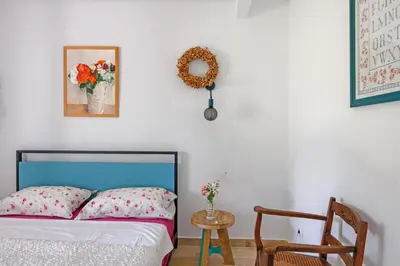 a bedroom with a bed and a chair and a clock at Mas de l'Aube in Mouriès