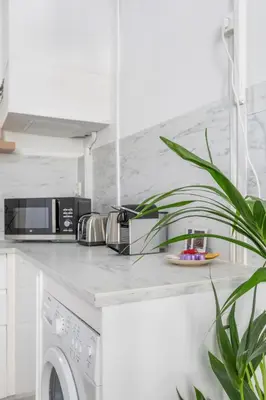 a white kitchen with a microwave and a dishwasher at T2 lumineux plein centre à 5 min du Cours Mirabeau confort, wifi, cuisine équipée in Aix-en-Provence