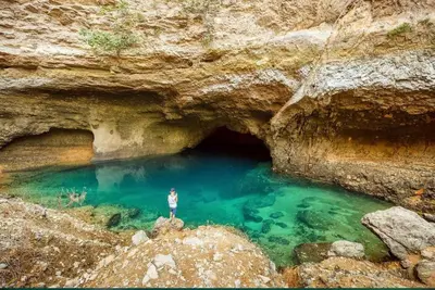 a man standing on a rock in a cave at Véritable maison de campagne nouvellement rénovée au pied du Lubéron in Cheval-Blanc