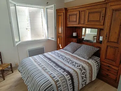 a bedroom with a bed and a large wooden cabinet at Véritable maison de campagne nouvellement rénovée au pied du Lubéron in Cheval-Blanc