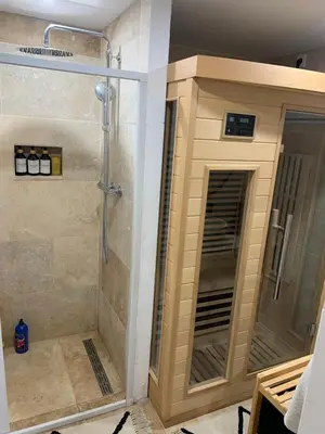 a shower with a glass door in a bathroom at Suite avec sauna in Pertuis