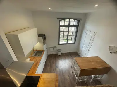 a small kitchen with a table and a window at Studio cosy climatisé au coeur du village de Saint Michel l'Observatoire in Saint-Michel-lʼObservatoire