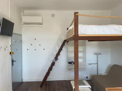 a small room with a bunk bed and a ladder at Studio cosy climatisé au coeur du village de Saint Michel l'Observatoire in Saint-Michel-lʼObservatoire
