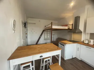 a small kitchen with a desk and a bunk bed at Studio cosy climatisé au coeur du village de Saint Michel l'Observatoire in Saint-Michel-lʼObservatoire