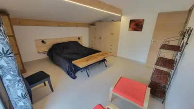 a bedroom with a bed and a bench in it at Le PEROTIN in Villes-sur-Auzon