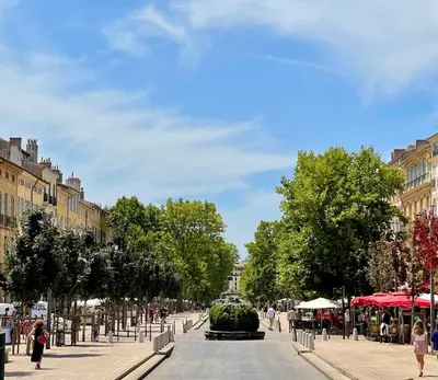 a street with a fountain in the middle of a city at Studio Tout confort Centre historique rue calme Climatisation in Aix-en-Provence