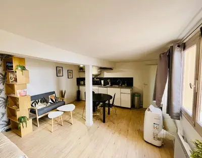 a living room with a couch and a table at Studio Tout confort Centre historique rue calme Climatisation in Aix-en-Provence