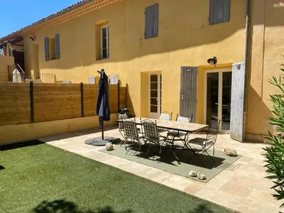 a patio with a table and chairs and an umbrella at Appartement de standing dans une bastide Aixoise in Aix-en-Provence