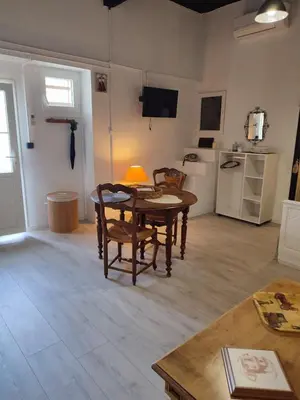 a living room with a table and chairs and a kitchen at Les Oliviers in Caumont-sur-Durance