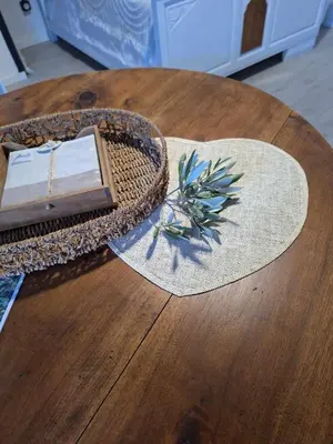 a straw hat sitting on top of a wooden table at Les Oliviers in Caumont-sur-Durance