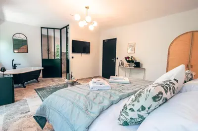 a bedroom with a large bed and a bath tub at Les Suites de l'Étang in Cucuron