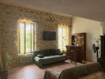 a living room with a couch and a table at Chez Dragos centre ville Lauris in Lauris