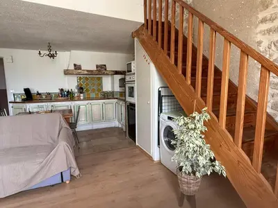 a living room with a staircase and a kitchen at Chez Dragos centre ville Lauris in Lauris