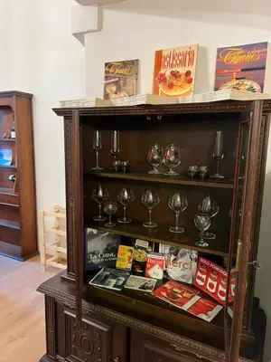 a book shelf with wine glasses and books at Chez Dragos centre ville Lauris in Lauris