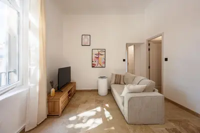 a living room with a couch and a tv at La Suite Provençale in Aix-en-Provence