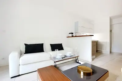 a living room with a white couch and a table at La Rotonde - Magnifique Appartement climatisé avec parking in Aix-en-Provence