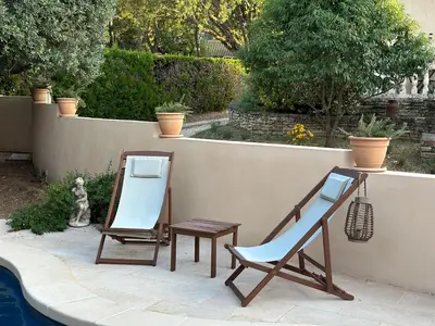two chairs and a mirror next to a pool at La Provence in Maubec