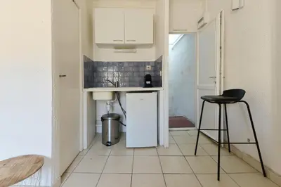 a small kitchen with a sink and a stool at Studio Lavande in La Fare-les-Oliviers