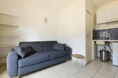 a living room with a blue couch in a room at Studio Lavande in La Fare-les-Oliviers