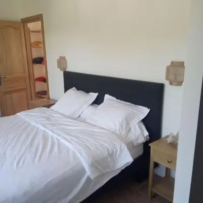 a bed with white sheets and pillows next to a table at Bastide 3 chambres 6personnes avec piscine sur Aix en Provence in Aix-en-Provence