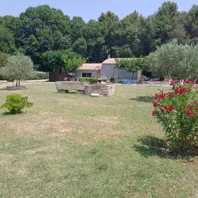 a park with a bench and flowers in the grass at Maison au coeur du Lubéron in Maubec