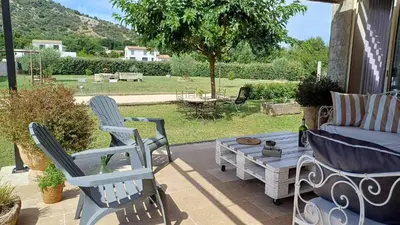 a patio with two chairs and a table and a couch at Maison au coeur du Lubéron in Maubec