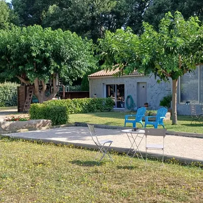 two blue chairs and a table in a yard at Maison au coeur du Lubéron in Maubec