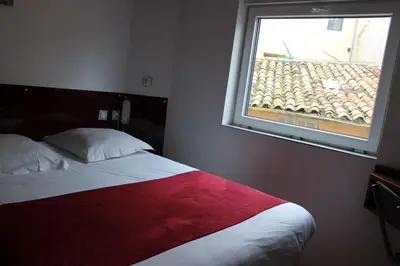 a bedroom with a red and white bed and a window at Hôtel des ARTS Aix in Aix-en-Provence