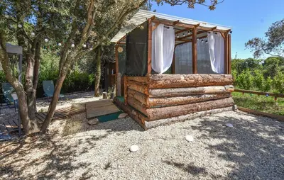 a log cabin with a window and trees at Gorgeous Stacaravan in Pernes-les-Fontaines