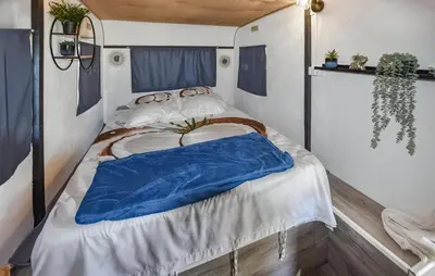 a bed with a blue blanket on it in a room at Gorgeous Stacaravan in Pernes-les-Fontaines
