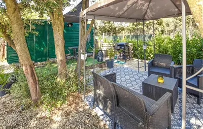 a patio with a table and chairs under an umbrella at Gorgeous Stacaravan in Pernes-les-Fontaines