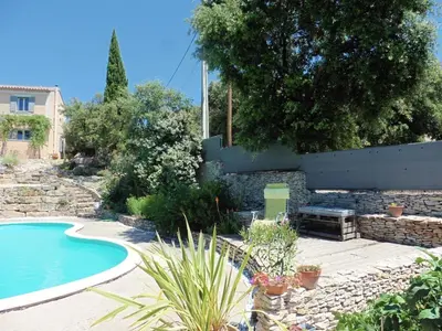 a backyard with a swimming pool and a stone wall at Pretty, spacious holiday home with private pool in Villes-sur-Auzon