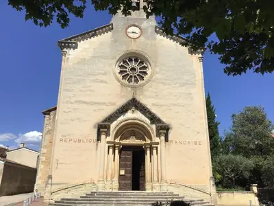 a tall building with a clock on top of it at Pretty, spacious holiday home with private pool in Villes-sur-Auzon
