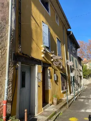 a yellow building with a door on a street at Calussine maison provençale in Pernes-les-Fontaines