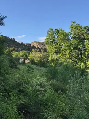a house in the middle of a hill with trees at La Bergerie de Chateau Fontvert in Lourmarin
