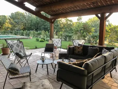 a patio with couches and chairs and a pool at La Bergerie de Chateau Fontvert in Lourmarin