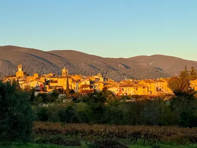 a group of yellow houses in front of mountains at La Bergerie de Chateau Fontvert in Lourmarin