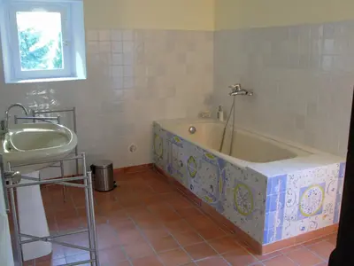 a bathroom with a bath tub and a sink at La Maison Cassée in Malemort-du-Comtat